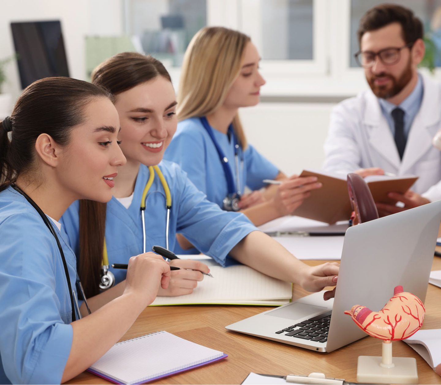 Medical team collaborating around a laptop.